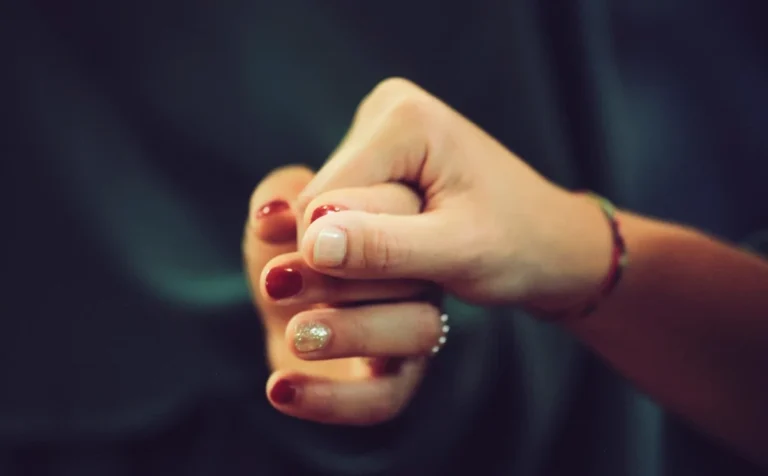 Coming out polyamorous: two people's hands clasped together in quiet support